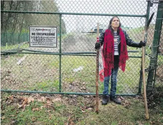  ??  ?? Kat Roivas, who is opposed to the expansion of the Kinder Morgan Trans Mountain pipeline, stands watch at an access gate on the company’s property in Burnaby.