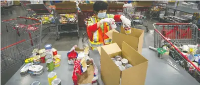  ?? ARLEN REDEKOP/FILES ?? A worker sorts items inside the Greater Vancouver Food Bank in Burnaby. Roughly six million Canadians experience food insecurity, which means inadequate or insecure access to food, and that's a problem for all Canadians, says Spencer van Vloten.