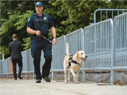  ?? GEMUNU AMARASINGH­E/AP ?? A police officer and a police dog patrol Thursday outside the U.S. Supreme Court in Washington.