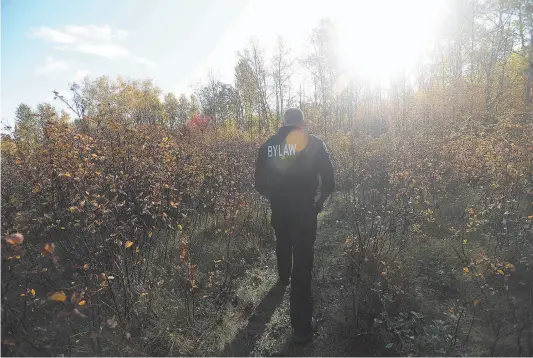  ?? CITIZEN PHOTO ?? A bylaw complance assistant officer checks a field along Queensway near a tent city that was discovered behind the Lombardy trailer park last week. Below: Part of a homeless camp behind the Lombardy trailer park.