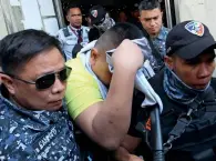  ?? Reuters ?? A police officer covers his face as he is escorted after his sentencing for the murder of a 17-year-old high school student in Manila, Philippine­s, on Thursday. —