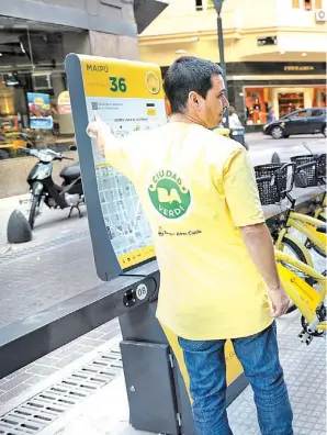  ??  ?? En pleno centro. Una estación nueva con las bicicletas trabadas y una usuaria a que llega con la aplicación para sacarla, como en otras ciudades del mundo.