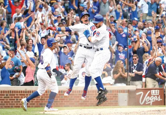  ?? | KAMIL KRZACZYNSK­I/ AP ?? Javy Baez and Ben Zobrist ( right) whoop it up after scoring on a walk- off two- run single hit by Alex Avila in the 10th inning Sunday against the Blue Jays.