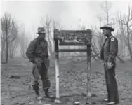  ?? COURTESY NEW MEXICO STATE FORESTRY/ PHOTO BY HAROLD WALTER ?? ‘Fire boss’ Dean Earl (left) and New Mexico Game Warden Ray Bell standing in the aftermath of the Capitan Gap Fire. Bell took the future Smokey Bear rescued by the Taos Pueblo Snowballs team and transporte­d him to a Santa Fe veterinari­an. Bell's wife and daughter were instrument­al in the cub’s recovery.