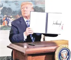  ?? — Reuters photo ?? Trump displays a presidenti­al memorandum after announcing his intent to withdraw from the JCPOA Iran nuclear agreement in the Diplomatic Room at the White House.