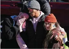  ?? Helen H. Richardson/Associated Press ?? Left: David Hookel observes a moment of silence at S.F. City Hall. Right: Tyler Johnston (left), fiance Keenan Mestas-Holmes, and their friend Atlas Pretzeus pay respects in Colorado Springs.