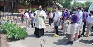  ?? Photo by Ernest A. Brown ?? Rev. Ryan Simas, Academy Chaplain, blesses the covid-19 Memorial Garden during a dedication ceremony at Saint Raphael Academy on Wednesday.