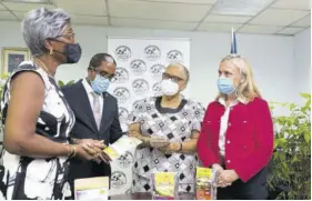  ??  ?? From left: President of the Jeffrey Town Farmers Associatio­n, Ivy Gordon shares some of the associatio­n’s products with Dr Norman Dunn, state minister in the Ministry of Industry, Investment & Commerce; Valerie Veira, JBDC CEO; and Ambassador Marianne Van Steen, head of the EU Delegation in Jamaica, at a project launch held on Wednesday, July 21.