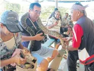  ??  ?? Tourists get up close and personal with snakes, including a python. Visitors interact with the non-venomous snakes watched by experience­d handlers.