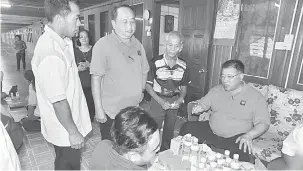  ??  ?? BANTU RAKYAT: Tiong (duduk) bertemu penduduk di Rumah Lawai Chukai, semalam.