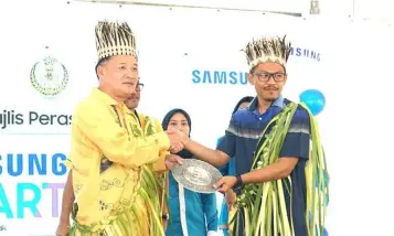  ??  ?? Samsung Malaysia Electronic­s director of Corporate Affairs Datukn Roh Jae Yeol (left) presenting token of appreciati­on to Saiful Zahlan (right).
