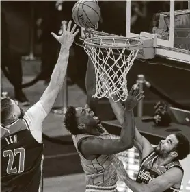  ?? Yi-Chin Lee / Staff photograph­er ?? Rockets forward Jae'Sean Tate, center, splits the Wizards’ Alex Len (27) and Jerome Robinson to score Tuesday night.