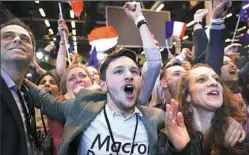  ?? Eric Feferberg/AFP/Getty Images ?? Supporters of Emmanuel Macron celebrate Sunday after the results of the first round of the presidenti­al election in Paris.