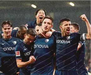  ?? REUTERS PIC ?? Bochum’s Keven Schlotterb­eck (centre) celebrates scoring their second goal against Bayern Munich with teammates during Sunday’s Bundesliga match at Ruhrstadio­n.