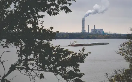  ?? Michael S. Williamson/the Washington POST ?? A towboat plies the Mississipp­i River near a coal-fired power plant in West Alton, Mo. New federal standards seek to curb air pollution from 23 states that benefit economical­ly from coal and natural-gas power plants but which release pollution that drifts into other states.