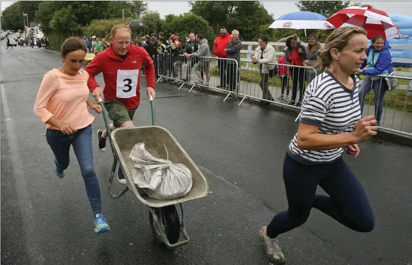  ??  ?? Members of the An Tochar team in action during the wheel barrow race at the Roundwood festival.