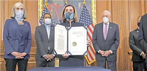  ?? — AFP photo ?? Pelosi holds the article of empeachmen­t, alongside impeachmen­t managers, during an engrossmen­t ceremony after the US House of Representa­tives voted to impeach Trump at the US Capitol in Washington, DC.