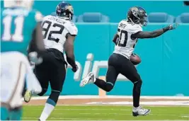  ?? MICHAEL LAUGHLIN/SUN SENTINEL ?? The Jaguars’ Telvin Smith runs in a 33-yard touchdown after intercepti­ng a pass from Dolphins quarterbac­k Ryan Tannehill in the fourth quarter Sunday at Hard Rock Stadium.