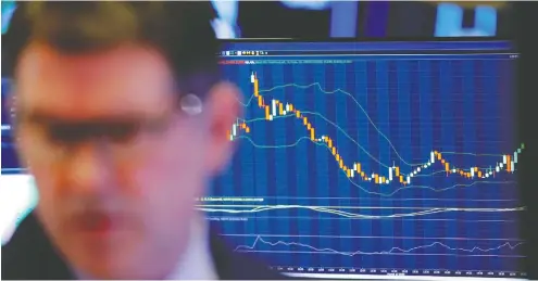  ?? LUCAS JACKSON / REUTERS ?? A trader works on the floor of the New York Stock Exchange on a dismal Monday which saw the Dow Jones drop a whopping 2,997 points.