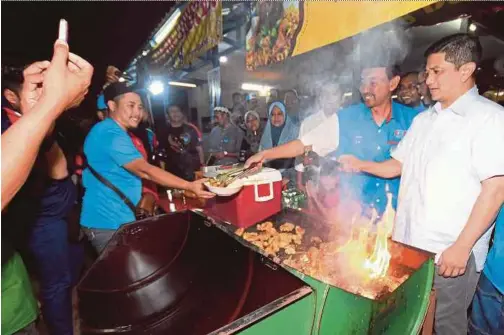  ?? BERNAMA PIC ?? PKR deputy president Datuk Seri Azmin Ali (right) and the party’s candidate for the Sungai Kandis by-election, Mohd Zawawi Ahmad Mughni (second from right), at a barbecue event in Shah Alam on Monday.