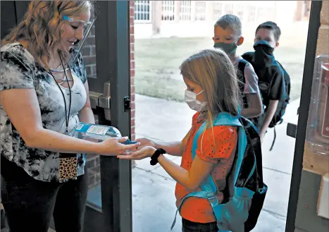  ?? LM OTERO/AP ?? Students use hand sanitizer before entering school Wednesday in Godley, Texas.