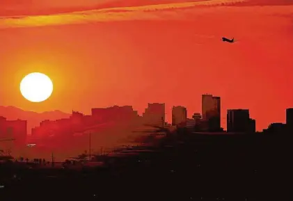  ?? Matt York/Associated Press ?? The sun sets over Phoenix on July 12. Millions of people around the Southwest are living through a historic heat wave.
