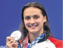  ?? KAI PFAFFENBAC­H • REUTERS ?? Kylie Masse of Canada poses with the silver medal she won in the 100-metre backstroke on Tuesday night at the Tokyo Olympics.