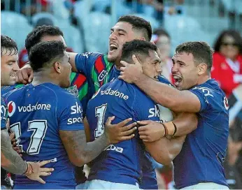  ??  ?? The Warriors’ celebrate Roger Tuivasa-Sheck’s match-winning try against the Dragons.