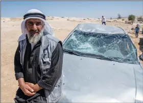  ?? ?? A Palestinia­n man leans on his smashed vehicle Sept. 30 following the attack by settlers.