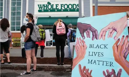  ?? Photograph: Cj Gunther/EPA ?? Protesters gather outside a Whole Foods Marketplac­e in support of employees that were sent homefrom work for wearing face masks that read ‘Black Lives Matter’, in Cambridge, Massachuse­tts, in June.