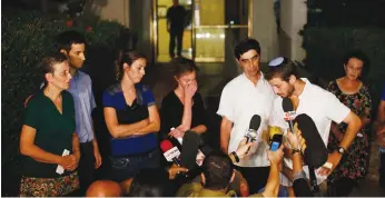  ?? (Nir Elias/Reuters) ?? TZUR GOLDIN (second from right), twin brother of Lt. Hadar Goldin, talks to the media in August 2014 alongside other family members outside their home in Kfar Saba.