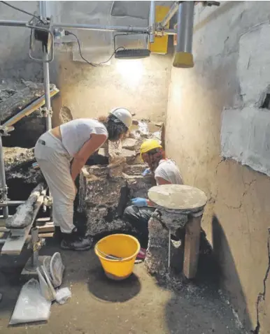  ?? // EFE ?? Dos arqueóloga­s trabajan en una de las paredes de los ‘apartament­os’ de Pompeya