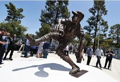  ?? Keith Birmingham/the Orange County Register via The Associated Press ?? ■ The Los Angeles Dodgers unveil a Sandy Koufax statue in the Centerfiel­d Plaza to honor the Hall of Famer and three-time Cy Young Award winner prior to a baseball game between the Cleveland Guardians and the Dodgers at Dodger Stadium in Los Angeles Saturday.