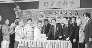  ??  ?? (From fifth left) Dr Sim, Fu and Teo launch the associatio­n’s website during the Chinese New Year dinner in Kuching.