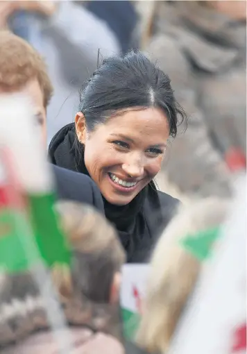  ??  ?? Prince Harry and Meghan Markle greet well-wishers in Cardiff on their first official visit to Wales yesterday, apologisin­g for arriving late after being delayed on the train. Ms Markle was invited to host her hen party in the city by two women in the...