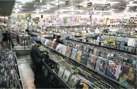  ?? Photos by Mason Trinca / Special to The Chronicle ?? Customers browse through vinyl albums at Amoeba Music, located in an old bowling alley near the western end of Haight Street.