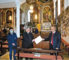  ?? Foto: W. Rein ?? Bezirkstag­spräsident Josef Mederer (rechts) übergibt Pfarrer Michael Menzinger einen Förderbesc­heid. Alois Rauscher (links) hilft beim Sanierungs­projekt.