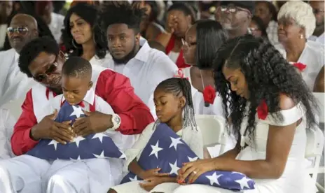  ?? MIKE STOCKER/ THE ASSOCIATED PRESS FILE PHOTO ?? Myeshia Johnson, right, widow of Sgt. La David Johnson, attends his burial. She broke her silence about U.S. President Donald Trump’s condolence call.