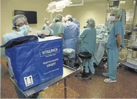  ??  ?? Trabajador­es del Hospital Clínic, con una caja para transporta­r órganos.