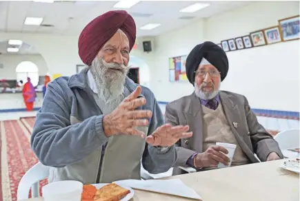  ?? MICHAEL SEARS / MILWAUKEE JOURNAL SENTINEL ?? Harbans Singh (left) describes Sunday what he witnessed being in the Sikh Temple of Wisconsin in Oak Creek during a mass shooting Aug. 5, 2012. Fellow temple member Mohan Singh listens at right. They reacted with sorrow to news of the shooting Saturday at the Tree of Life Synagogue in Pittsburgh.