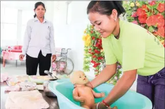  ?? PHA LINA ?? A trainee maid receives instructio­ns from a supervisor while practising skills at a training school in Phnom Penh in 2013.