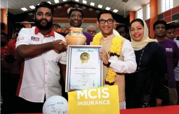  ??  ?? Buvaneswar­en (left) presents the MBR certificat­e to Ahmad Faizal. — Bernama photo