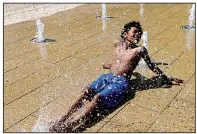  ?? AP/SUSAN WALSH ?? Amari Rogers, 11, of Capitol Heights, Md., finds solace Saturday in a fountain in Washington as temperatur­es soared into the mid-90s.