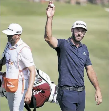  ?? Jim Weber/Associated Press ?? Dustin Johnson acknowledg­es the crowd after an eagle on the 18th hole Sunday in final round of the St. Jude Classic in Memphis, Tenn.