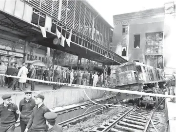  ??  ?? Fire fighters and onlookers gather at the scene of a fiery train crash at the Egyptian capital Cairo’s main railway station. — AFP photo