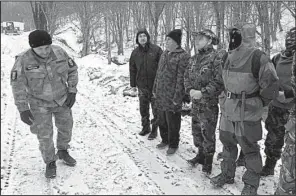  ?? Los Angeles Times/SHASHANK BENGALI ?? Vladimir Rusev (left) sizes up volunteers at a training session near Bulgaria’s border with Turkey. “We’re ready for a war,” Rusev said. “We’re guarding against criminals and terrorists who are working against the interests of Europe and the United...