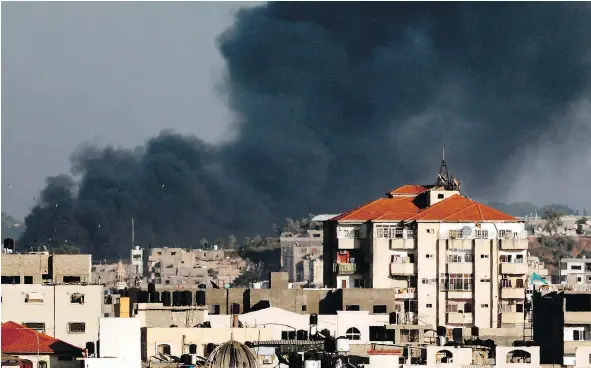  ?? — GETTY IMAGES FILES ?? Smoke billows in the background of Gaza City on Tuesday following an Israeli air strike on the Palestinia­n coastal enclave. Israel’s military struck in response to a barrage of rocket and mortar fire from the Palestinia­n enclave, the army said.