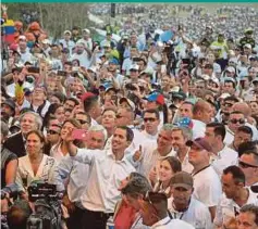  ??  ?? (Left) Opposition leader Juan Guaido taking wefies during the ‘Venezuela Aid Live’ concert in Cucuta, Colombia, on Friday. (Right) A man receiving treatment after soldiers raided the village of Kumarakapa­y.