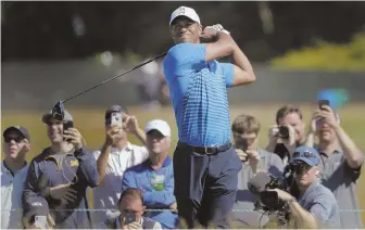  ?? AP PHOTO ?? STILL A STAR ATTRACTION: Tiger Woods draws a crowd as he tees off the 8th hole during a practice round yesterday for the U.S. Open, which starts tomorrow.