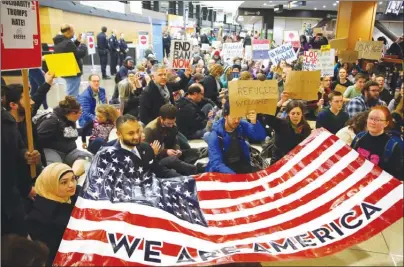  ?? The Associated Press ?? Demonstrat­ors at Seattle-Tacoma Internatio­nal Airport protest President Donald Trump’s first travel ban last January. Local astrologer Heather Zais predicts that in 2018, people will again be speaking out for freedom and equality and will be rallying...